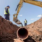 Ilustración de una excavadora realizando una excavación para instalar una red subterránea de gas y electricidad