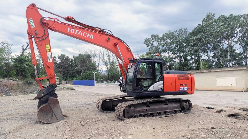 Imágenes detalladas de la excavadora Hitachi 210 LC, destacando su potencia y eficiencia en proyectos de construcción y movimiento de tierras.